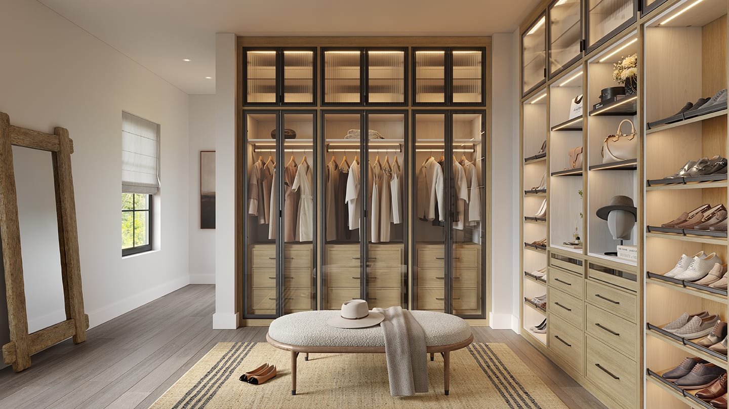 Dressing area in walk in closet with custom dresser, shoe wall in natural wood grain finish by California Closets