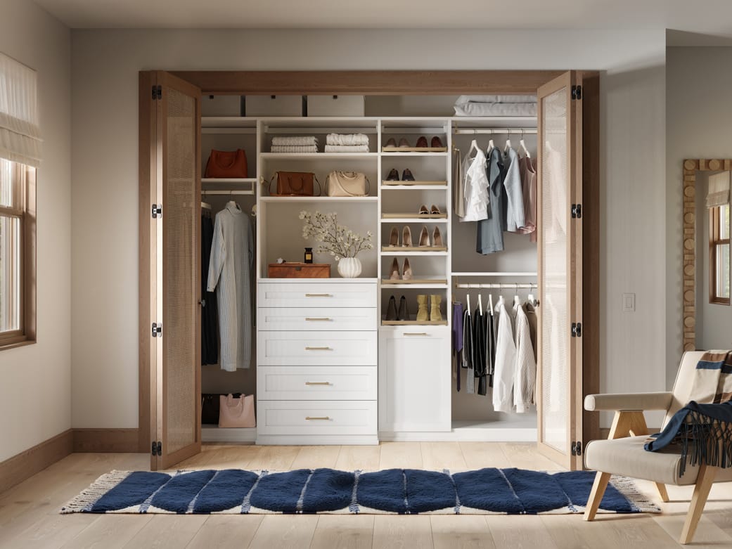 Reach in wardrobe closet featuring drawers and integrated baskets by California Closets