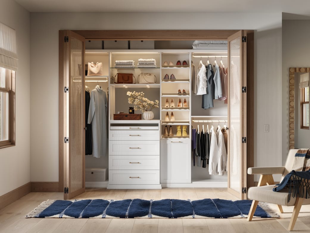 Reach in closet with customized lighting, built in drawers and shoe racks by California Closets